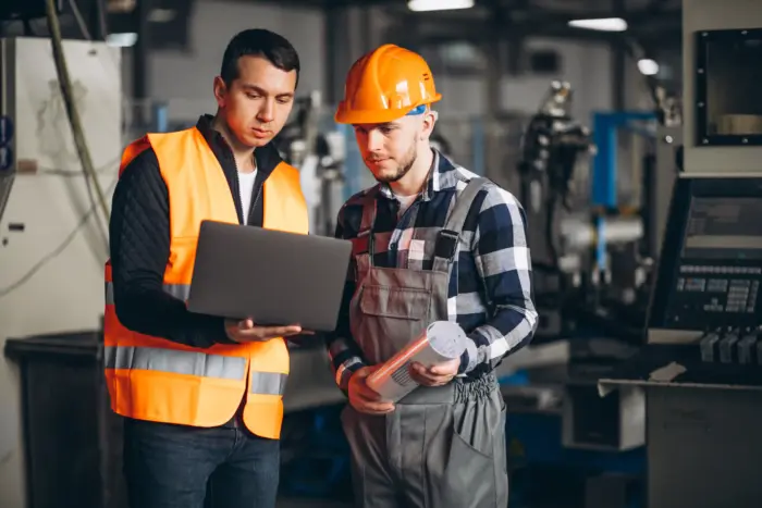 Dos compañeros revisando la producción en fábrica